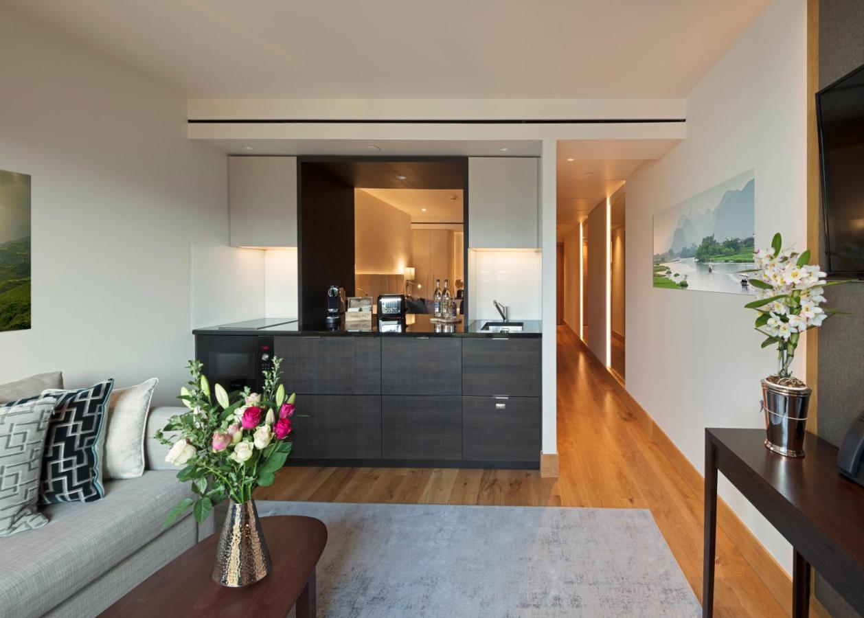 Tower Suites By Blue Orchid London Exterior photo The photo showcases a modern and stylish interior space, likely a living area of a luxurious apartment or hotel suite. 

- **Bar Area**: There is a sleek bar counter that features a variety of bottles and glassware, suggesting a well-equipped space f