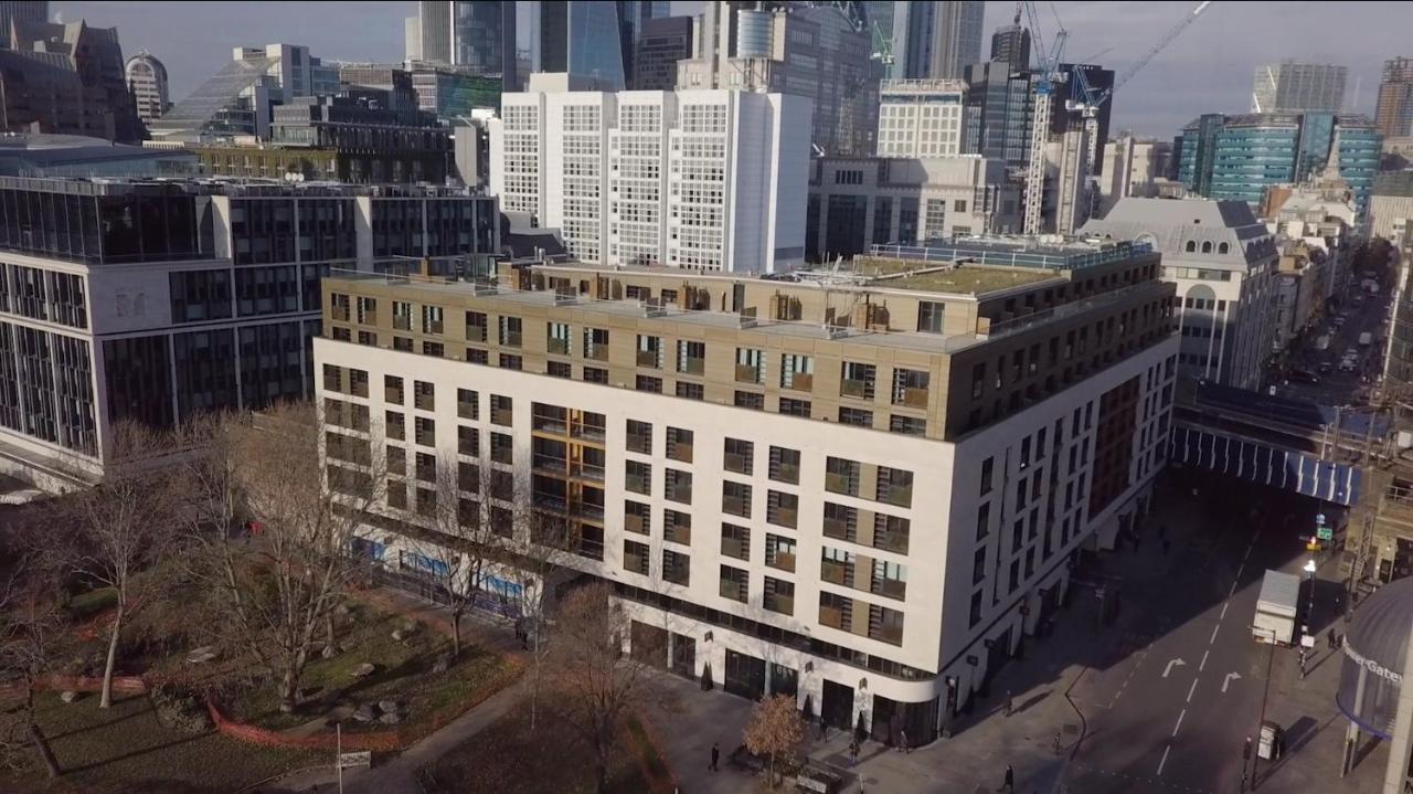 Tower Suites By Blue Orchid London Exterior photo The photo shows a large, modern building with a combination of white and light-colored facades. The structure has multiple floors and features a series of square windows, providing a contemporary architectural style. Surrounding the building, there a